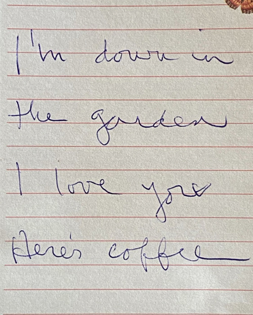 A white piece of paper on which is written: I’m down in the garden. I love you. Here’s coffee.